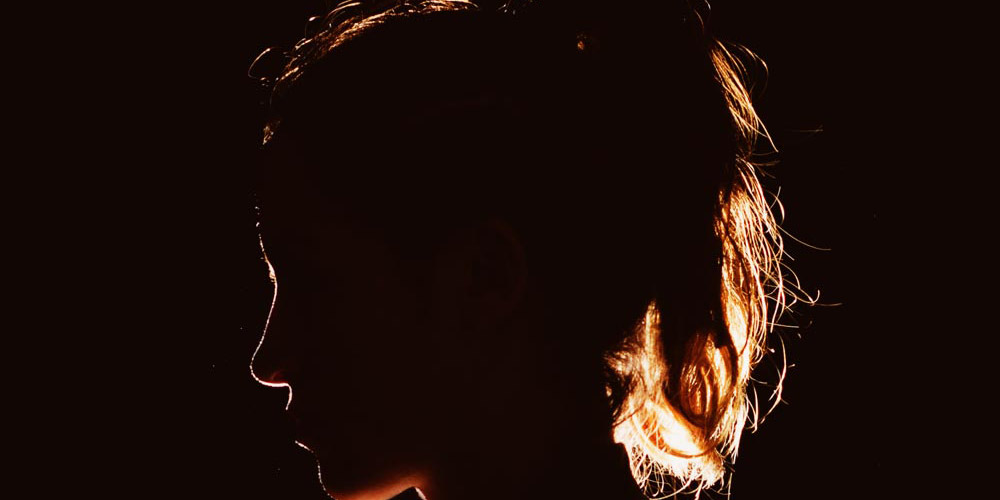 Woman in profile backlit and silhouetted