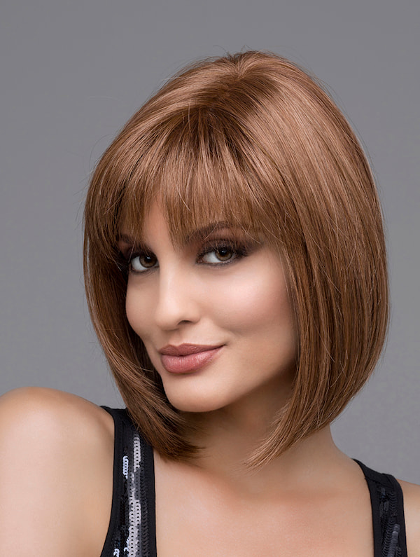 headshot of model wearing brown chin length wig with bangs