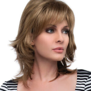 headshot of model wearing shoulder length layered wig with bangs